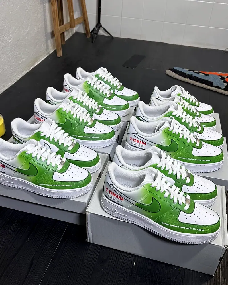 Pedido de tênis brancos com degradê verde e a marca Yamaha, pintados à mão e arrumados sobre as caixas